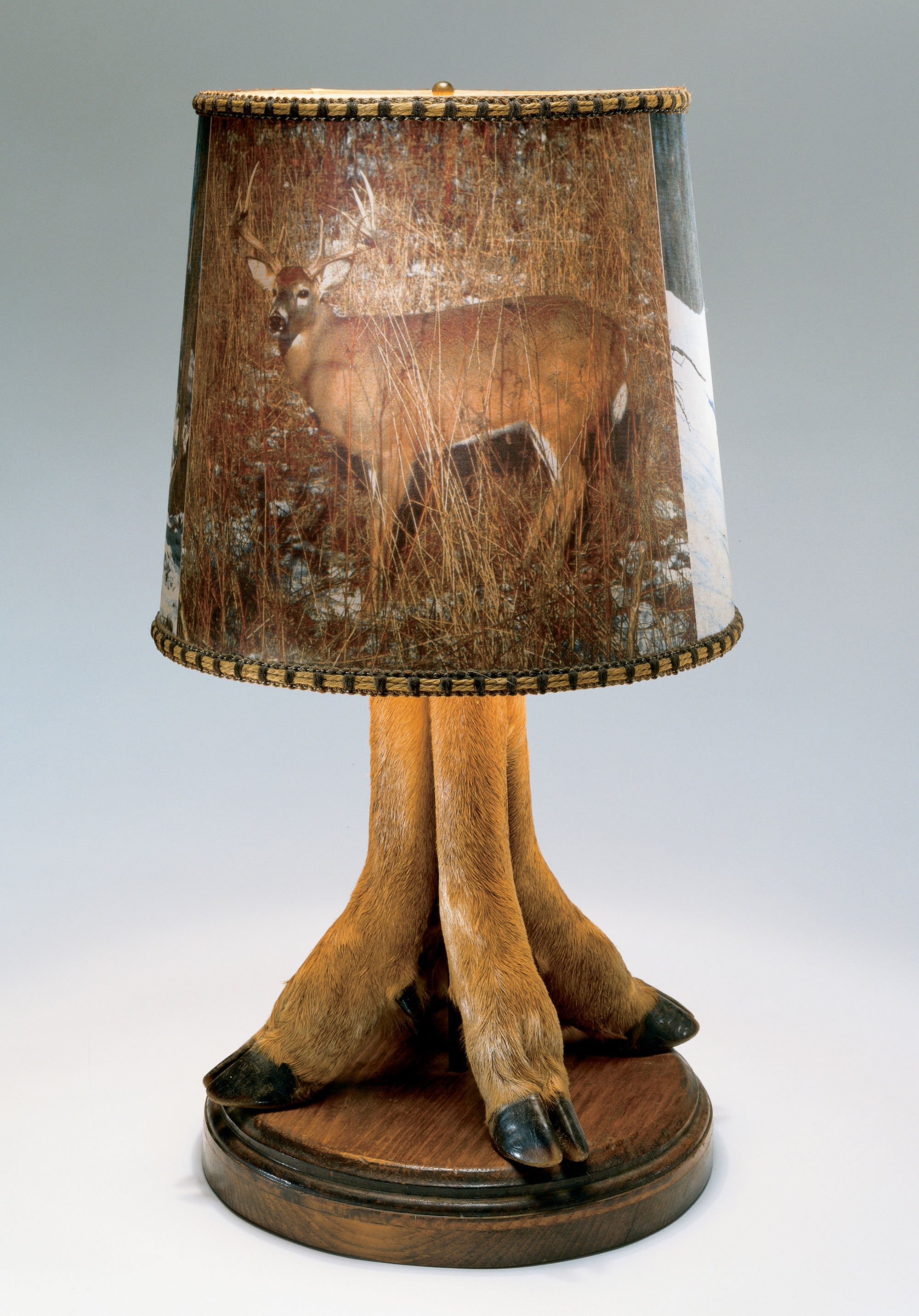 A photograph of a trophy lamp with deer forelegs as base, circa 1970.