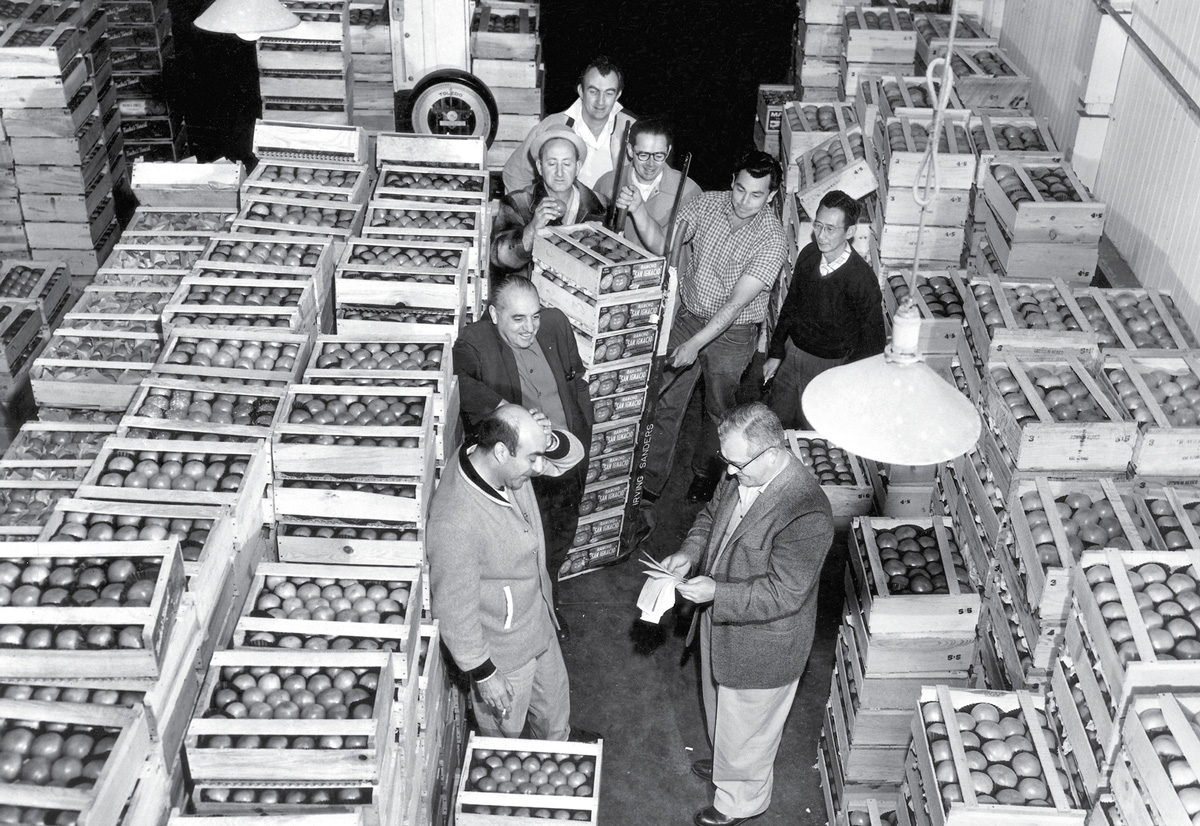 A photograph of Barry Sanders’s father in the market in the late nineteen forties. Sanders writes: “The person holding the receipts in the center of the photograph is my old man. The picture, taken for a local LA newspaper such as the 