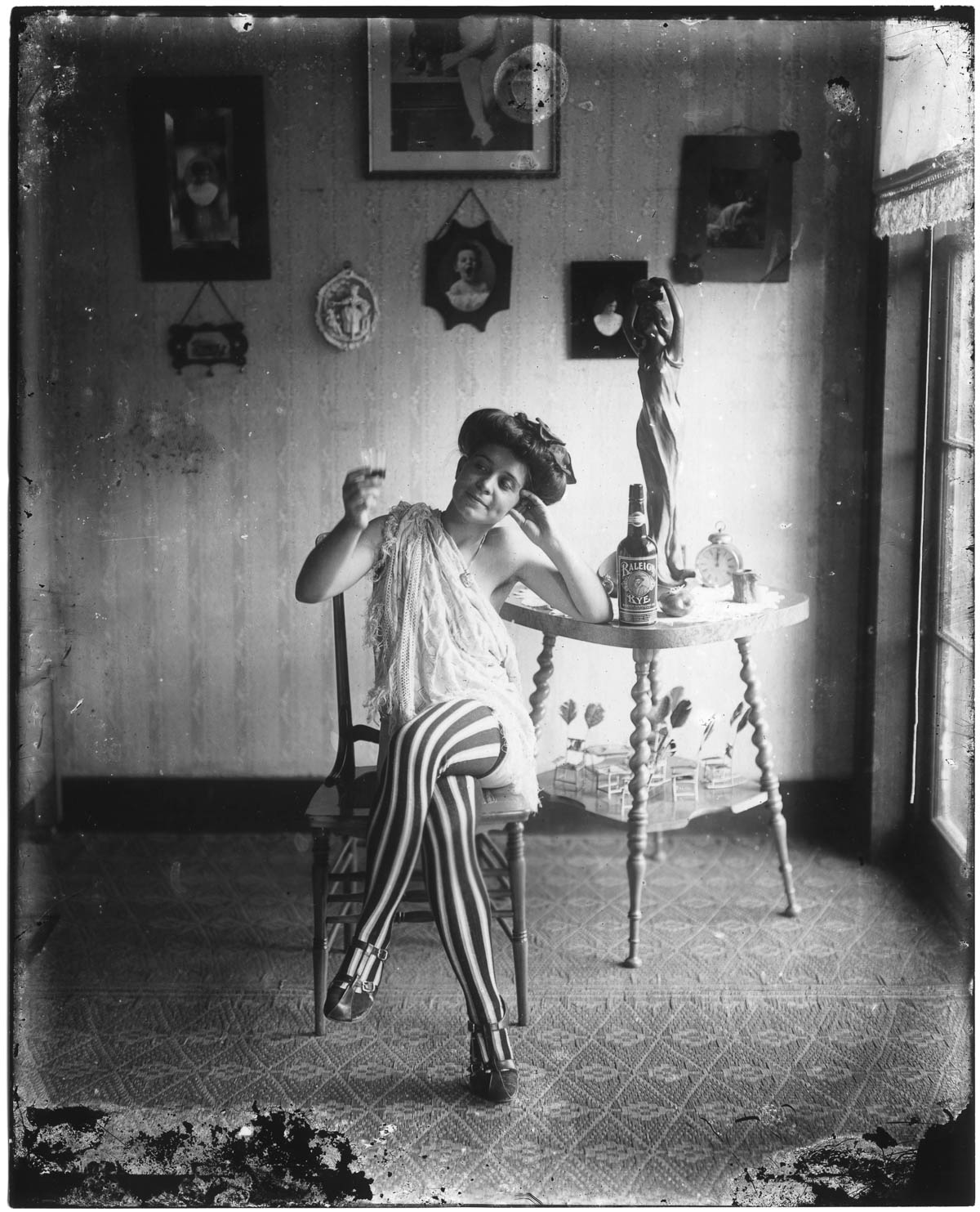 A photograph of a woman wearing striped stockings taken by E. J. Bellocq in Storyville, the red light district of New Orleans, circa nineteen twelve. 