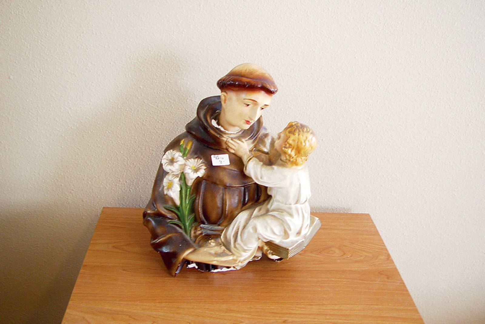 A photograph titled “What’s Mine Is Yours” depicting a religious statuette marked with a price tag, from Casey Logan’s two thousand and seven artist project titled “Shopping in Sin.”