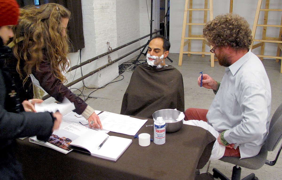 A photograph of Sina Najafi, editor of Cabinet, being shaved at work by former roomate and amateur barber Richard Fleming. 