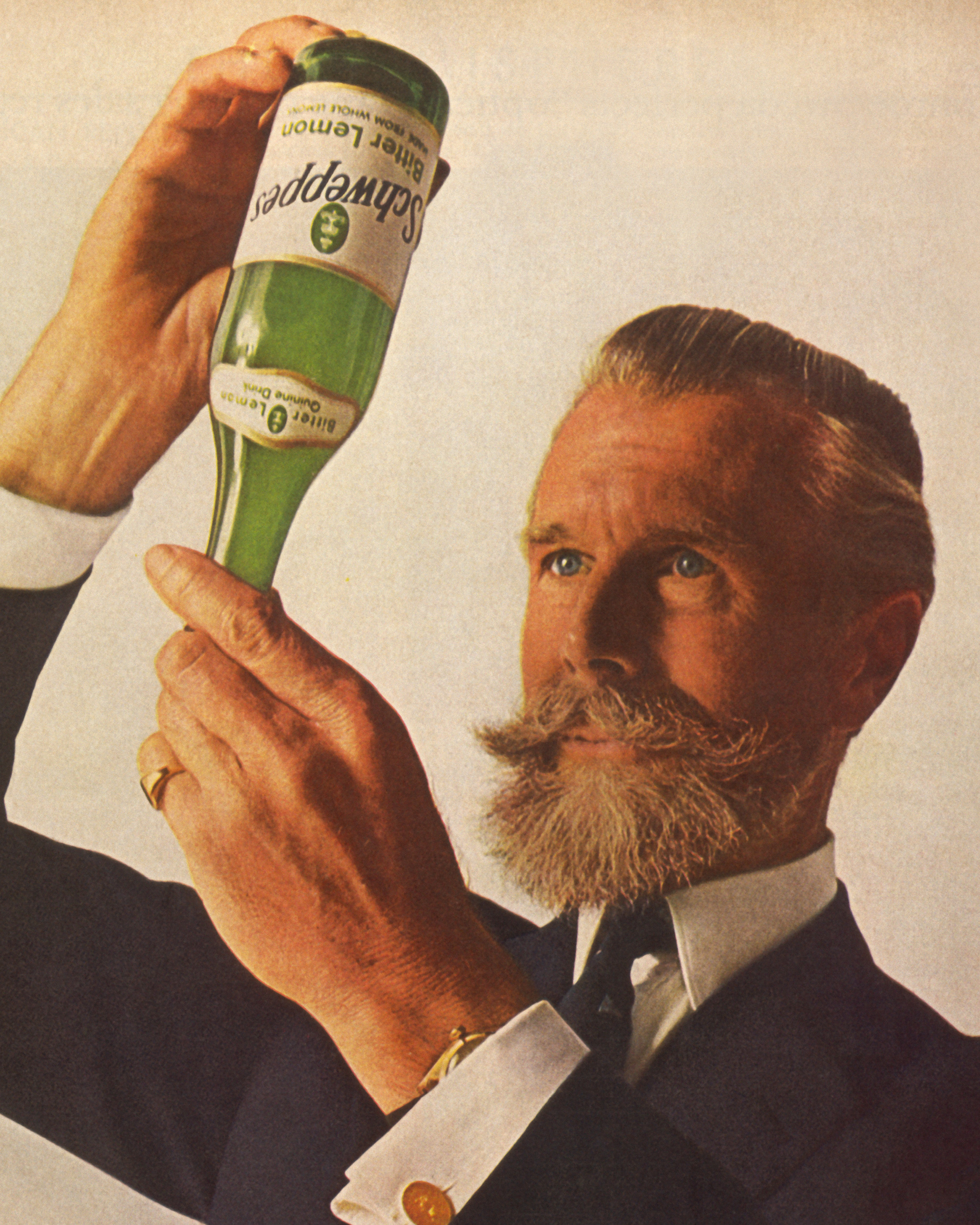 A June 11th nineteen sixty-five Schweppes ad in Time magazine. The ad depicts the president of the company, “Commander Whitehead,” inspecting the bubbles in a bottle of Schweppes bitter lemon.