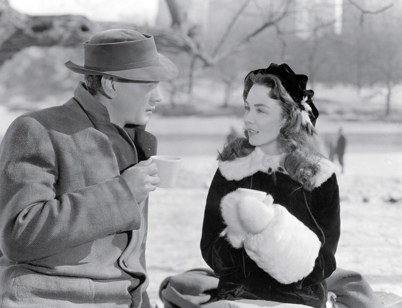 A still from William Dieterle’s nineteen forty-eight film “Portrait of Jennie”, showing Joseph Cotten and Jennifer Jones sipping hot chocolate in Central Park. 