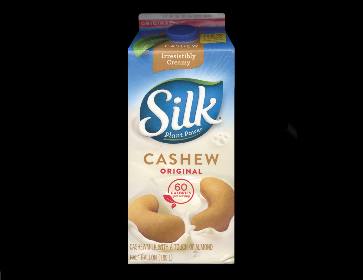 An image of Silk original creamy cashew milk featuring two cashew nuts lying side by side.