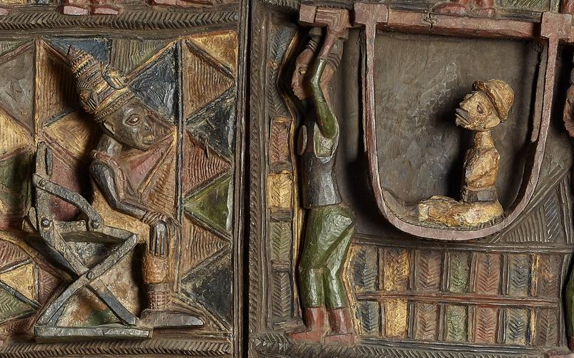 Early twentieth-century door panels by Yoruba artist Olówè of Isè from the palace of the Ogoga (king) of Ikere in present-day Nigeria. The Ogoga sits in a throne across from a white man, who is being carried in a hammock.