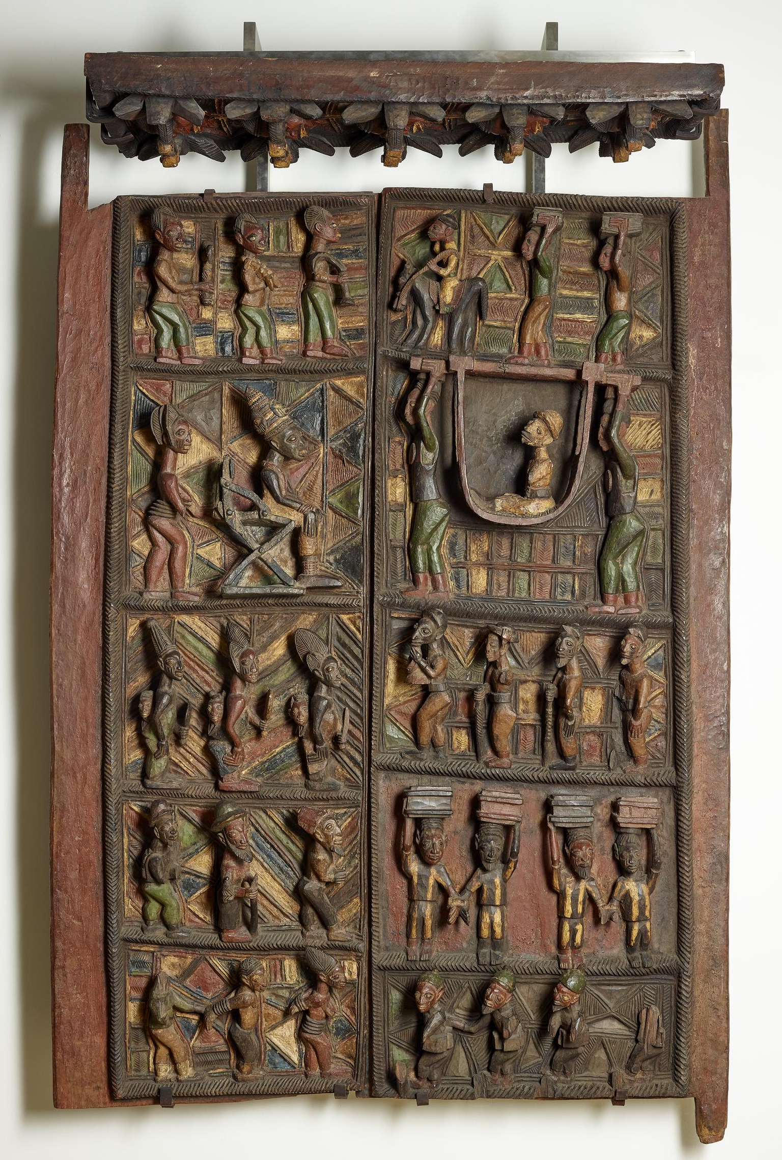 Early twentieth-century door panels by Yoruba artist Olówè of Isè from the palace of the Ogoga (king) of Ikere in present-day Nigeria. The Ogoga faces Captain W. G. Ambrose, a British commissioner traveling in a hammock.