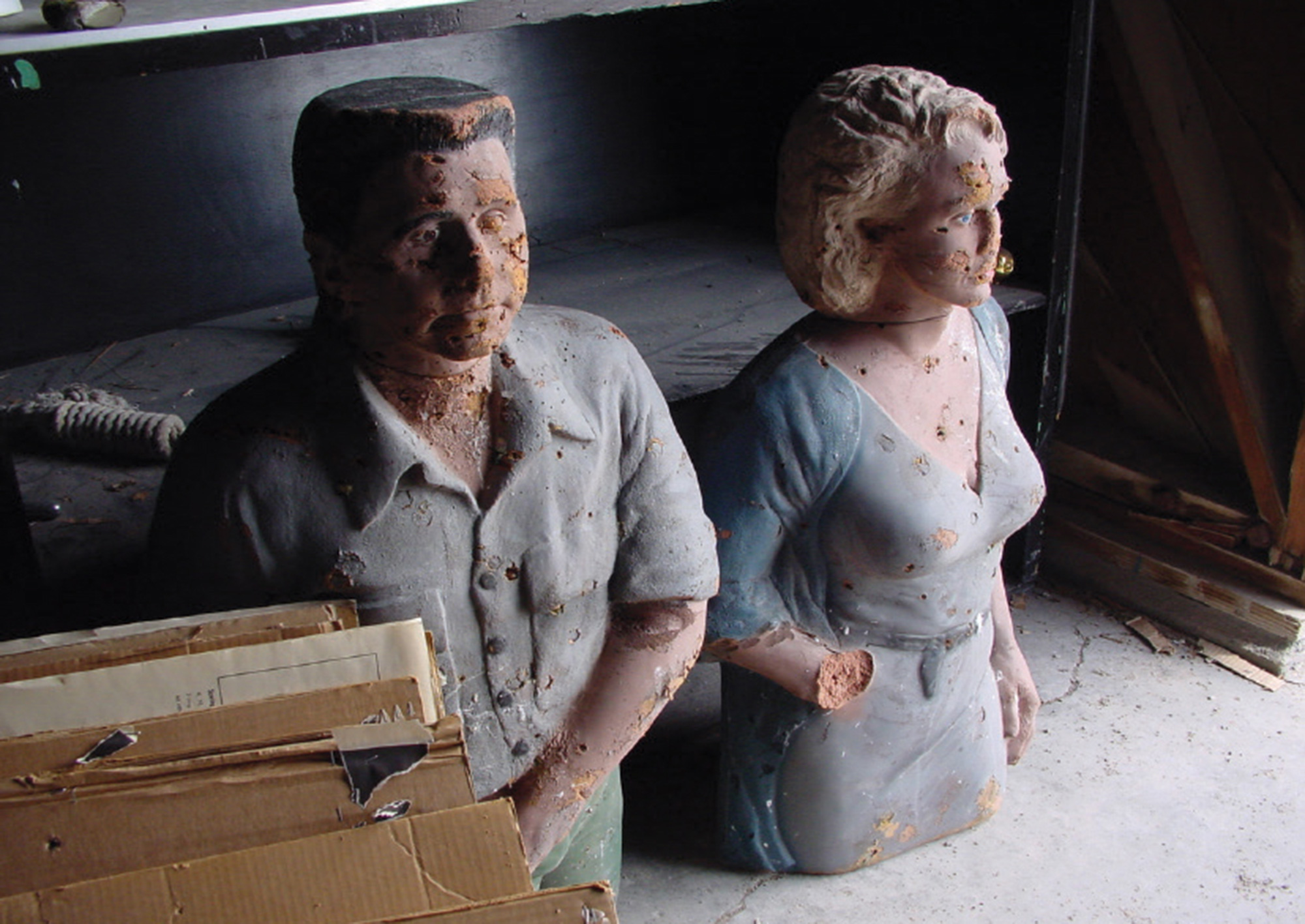 A photograph of two used police training mannequins, one male torso and head next to one female torso and head, both clothed.