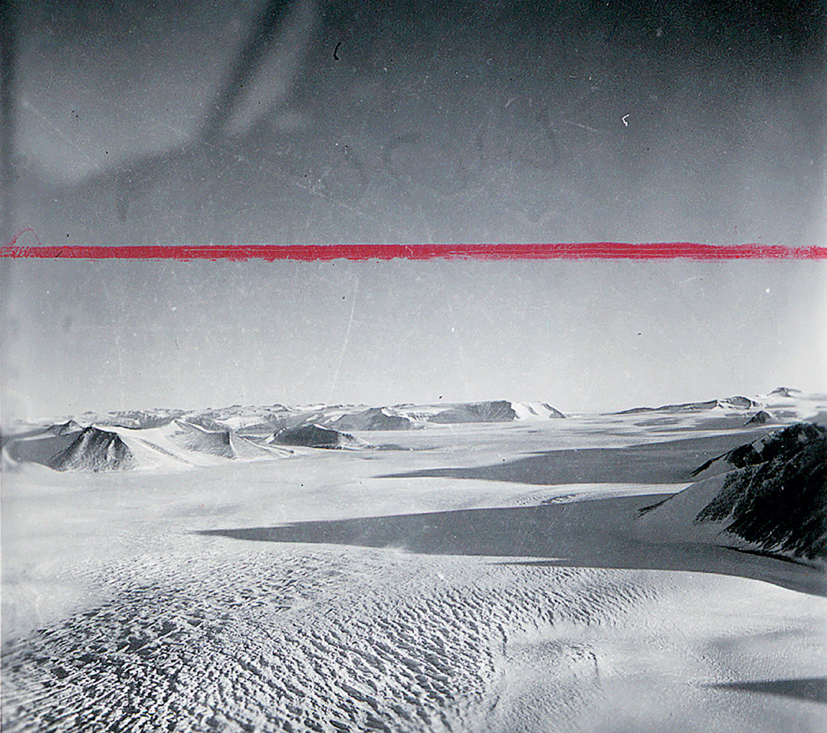 A photograph of an Antarctic landscape with red crop marks along the top.