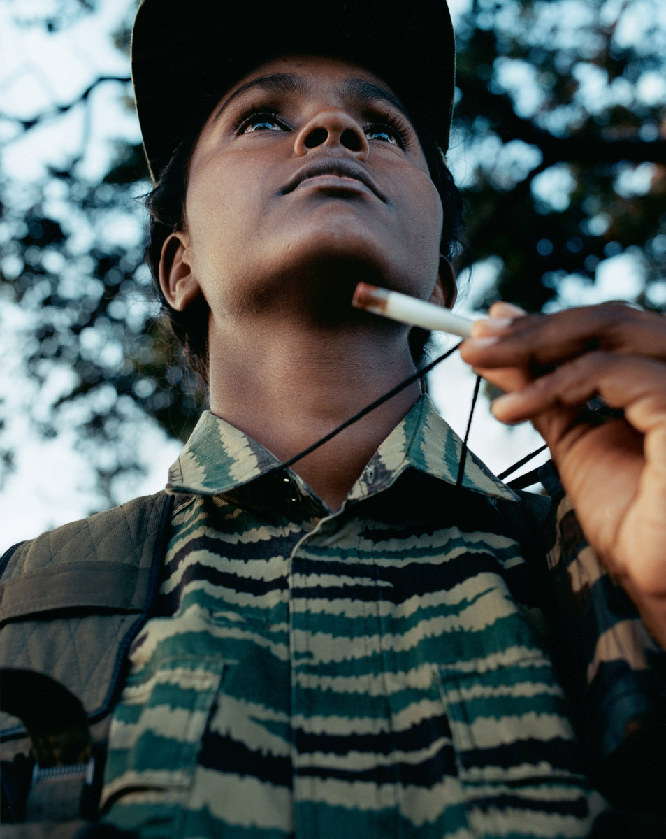 A photograph of a Bird of Freedom member holding up her cyanide vial around her neck.