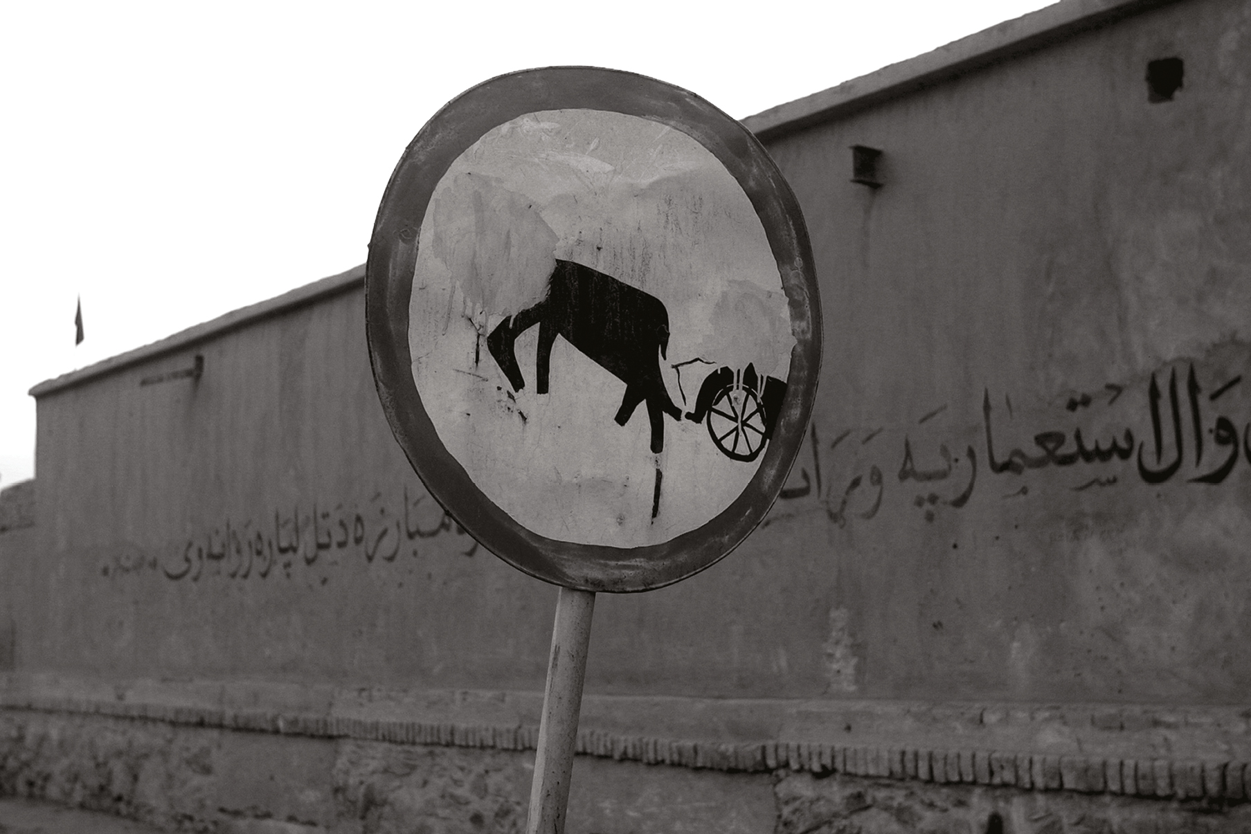 Front image of a postcard featuring a photograph by Thomas Dworzak of a Taliban-modified street sign.
