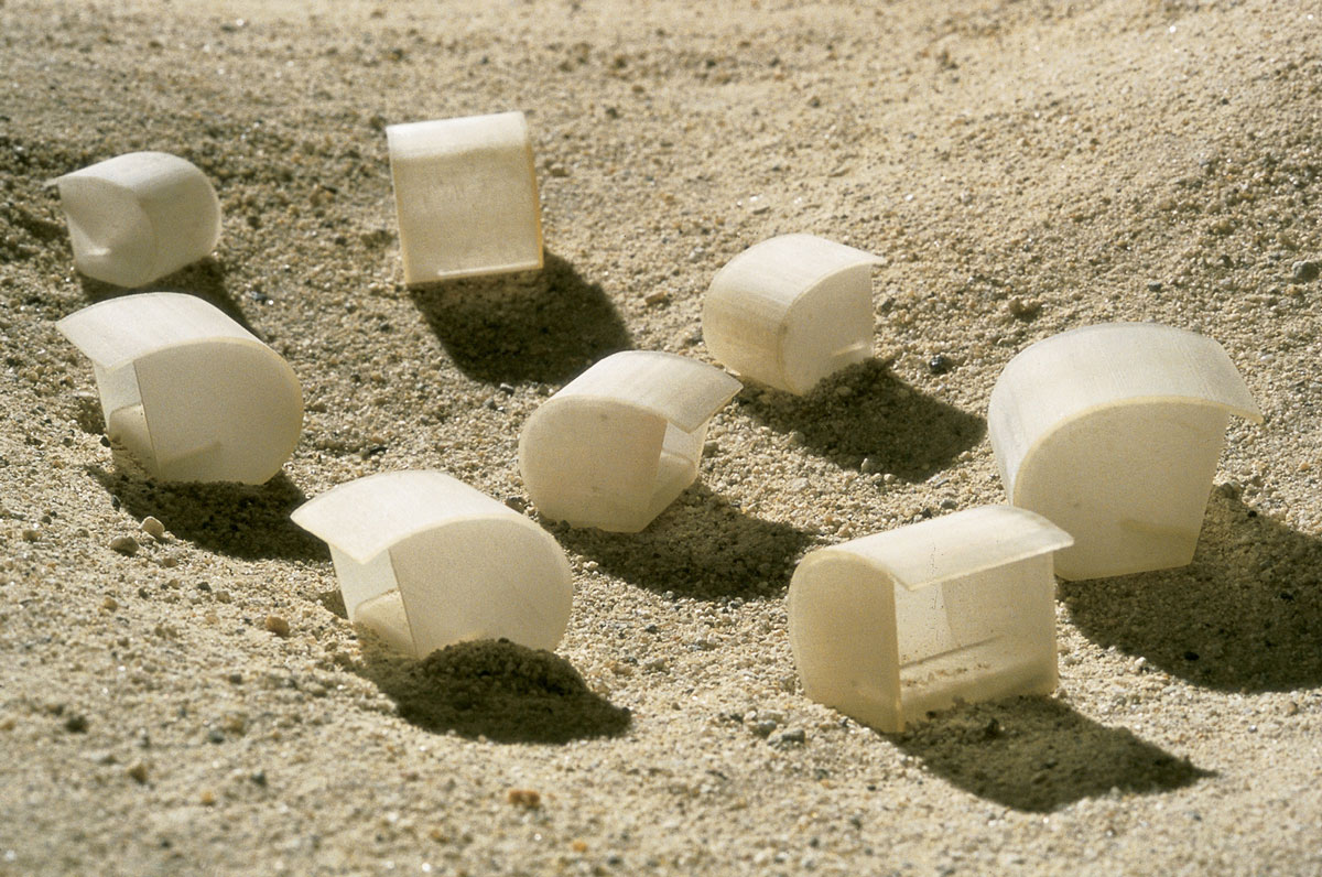 A photograph of hermit shell prototypes on the sand.