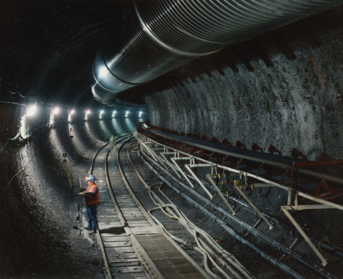 A photograph of an engineer standing in Yucca Mountain Project's underground tunnel.