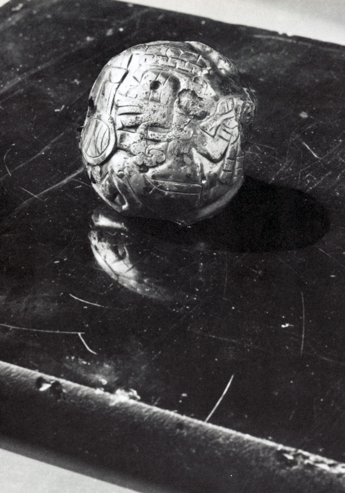 A photograph of a pre-Columbian Central American obsidian mirror, pictured with pyrite object.