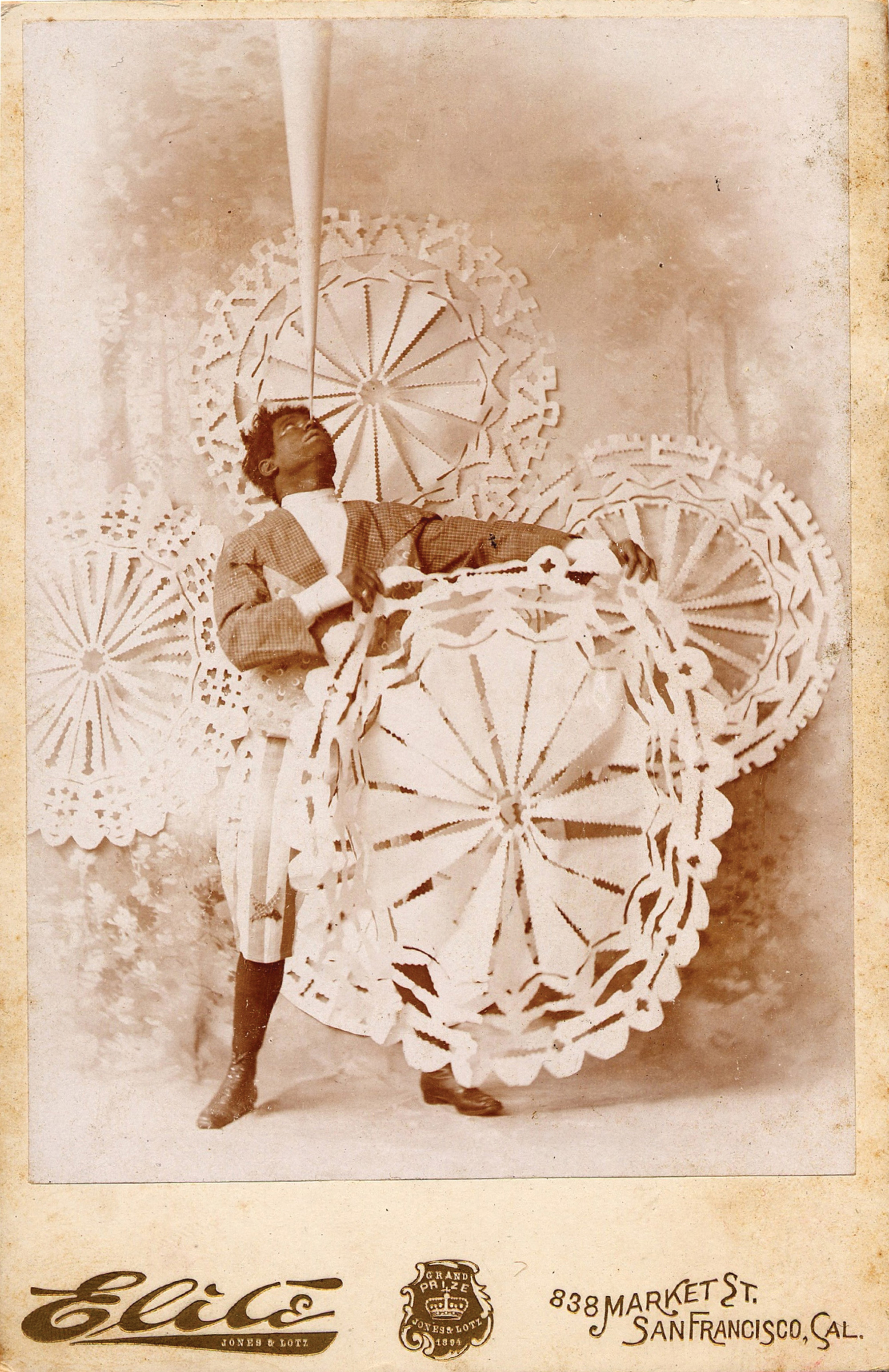 Sepia postcard image of man balancing giant paper cut-outs, San Francisco, California.