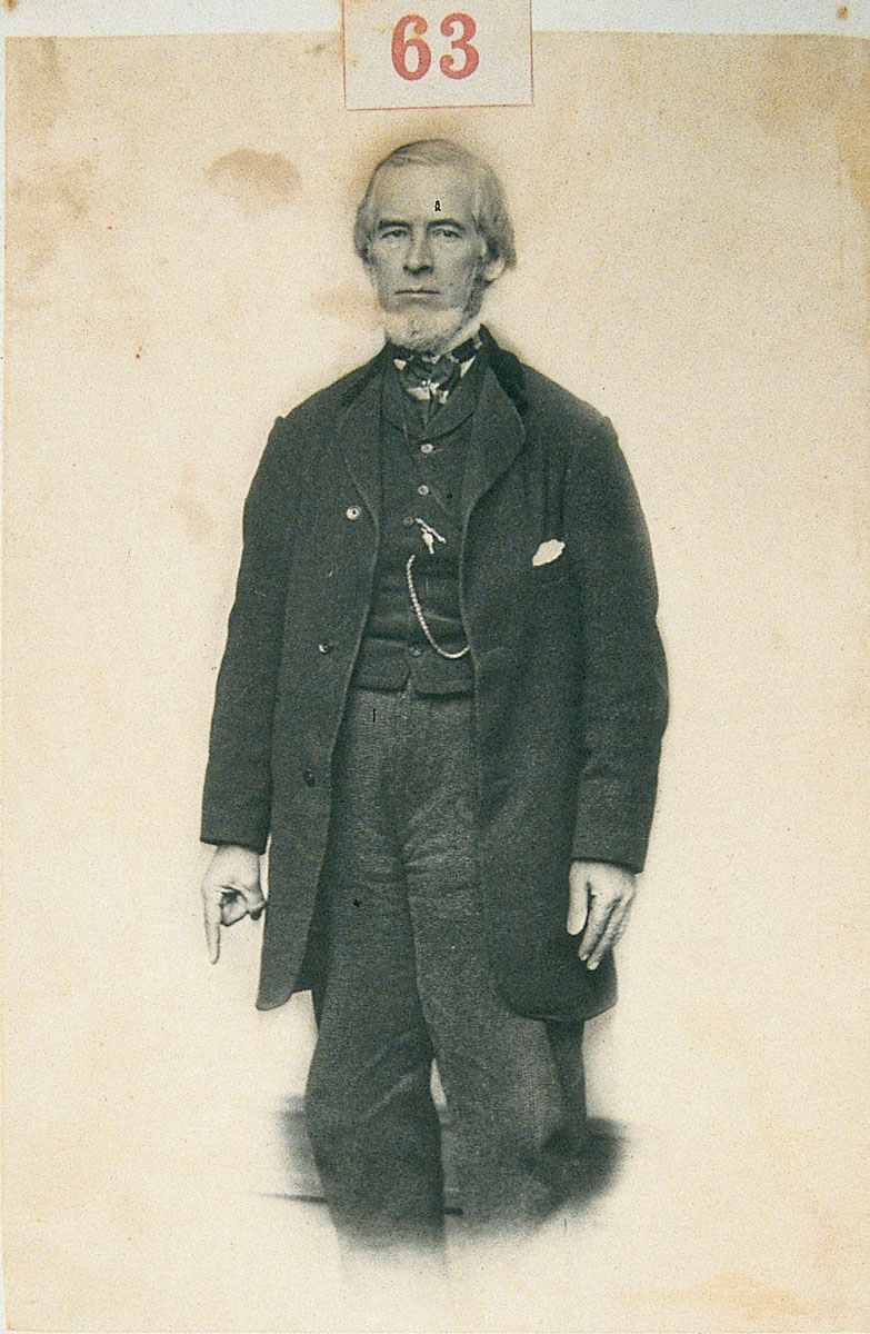 Photograph of a man pointing down, his lower body blurred.