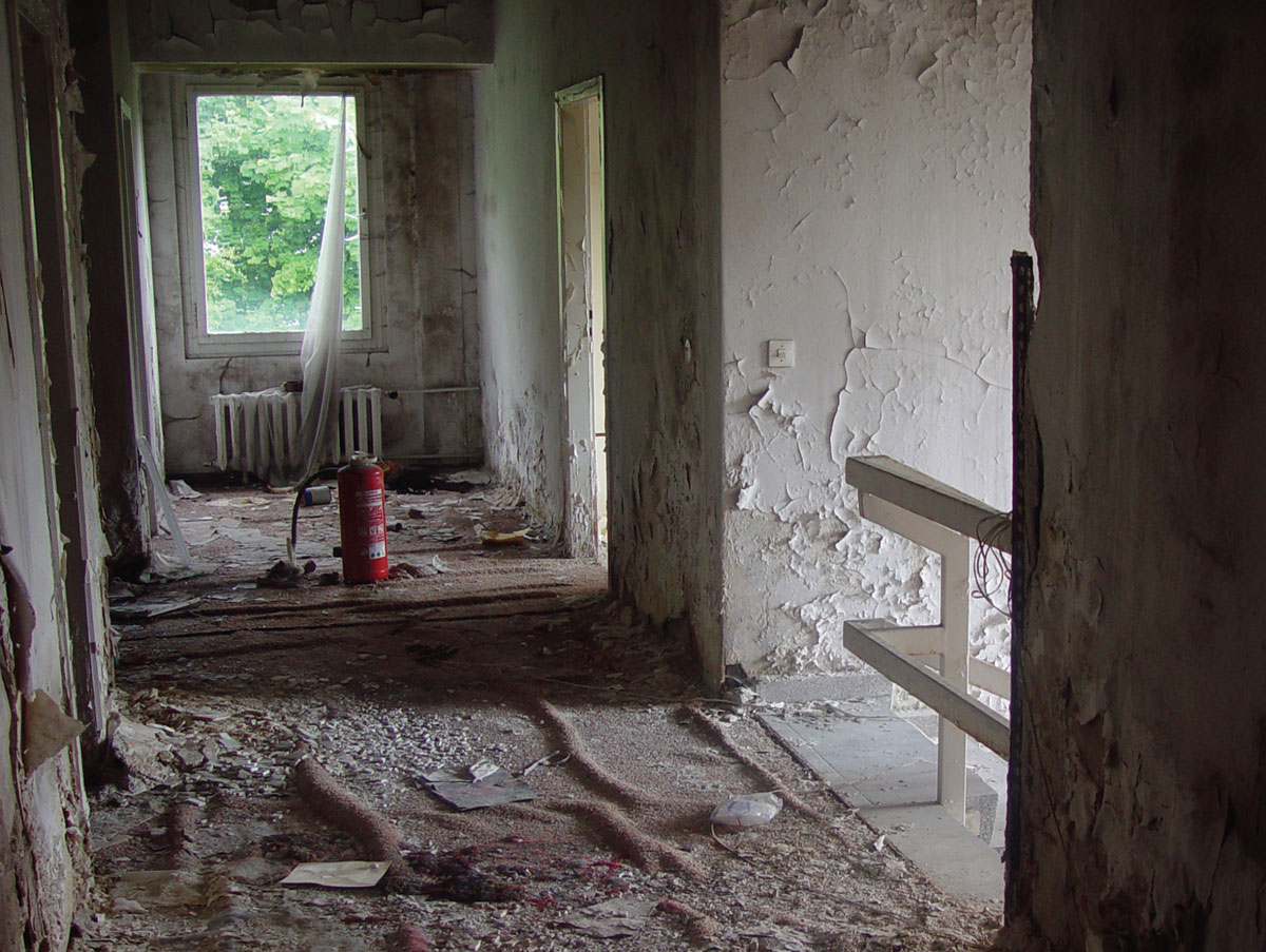 A photograph of an abandoned, dilapidated hallway in the former building of the official diplomatic mission of the Republic of Iraq.