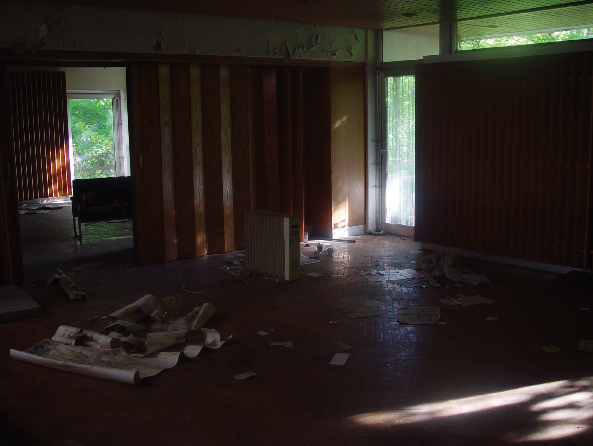 A photograph of a dark wooden room with office supplies on floor.