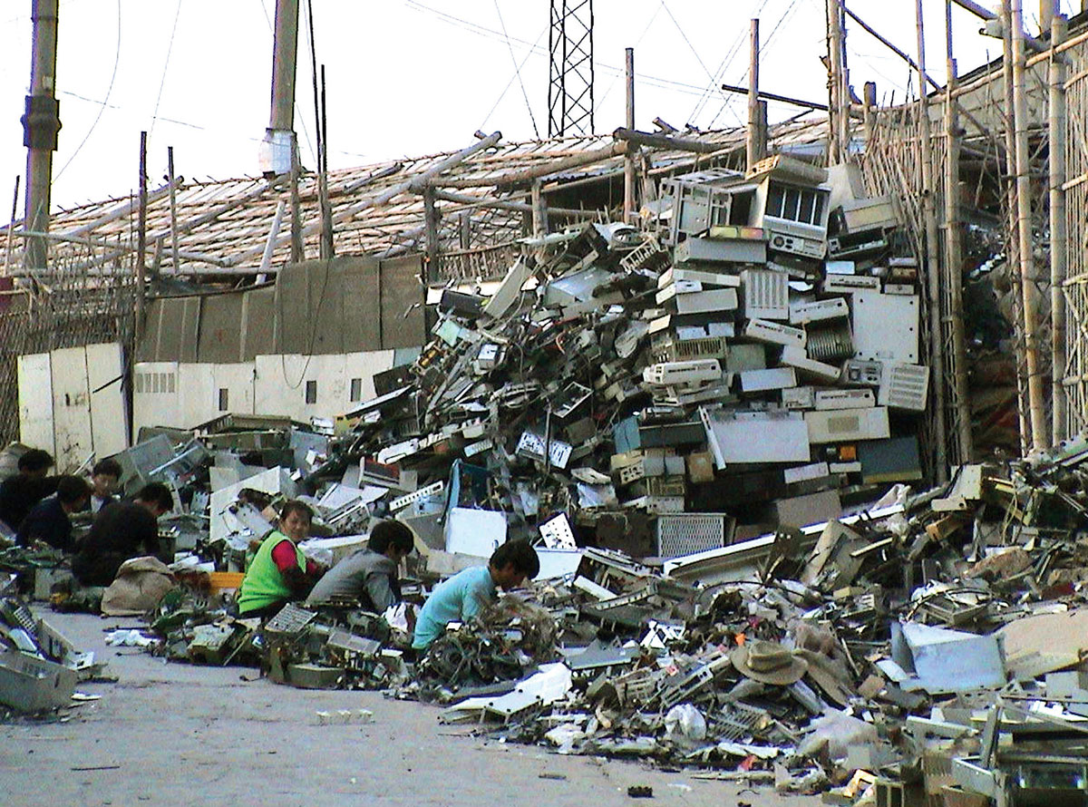 A typical E-scrapping operation. 100,000 such migrant workers work in Guiyu breaking down imported computers in hundreds of small operations like this one in a four-village area surrounding the Lianjiang River. Guiyu, China, December 2001. Courtesy Basel Action Network.