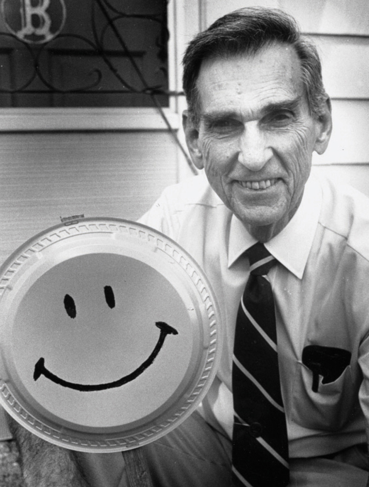A photograph of Harvey Ball holding up his smiley face design. 