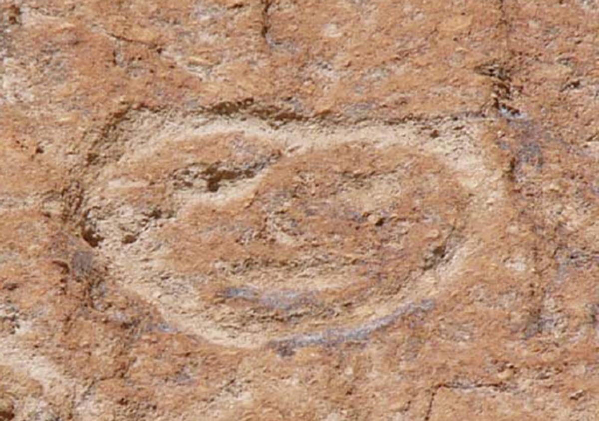 A photograph of a smiley face–shaped petroglyph at the Bandelier National Monument.