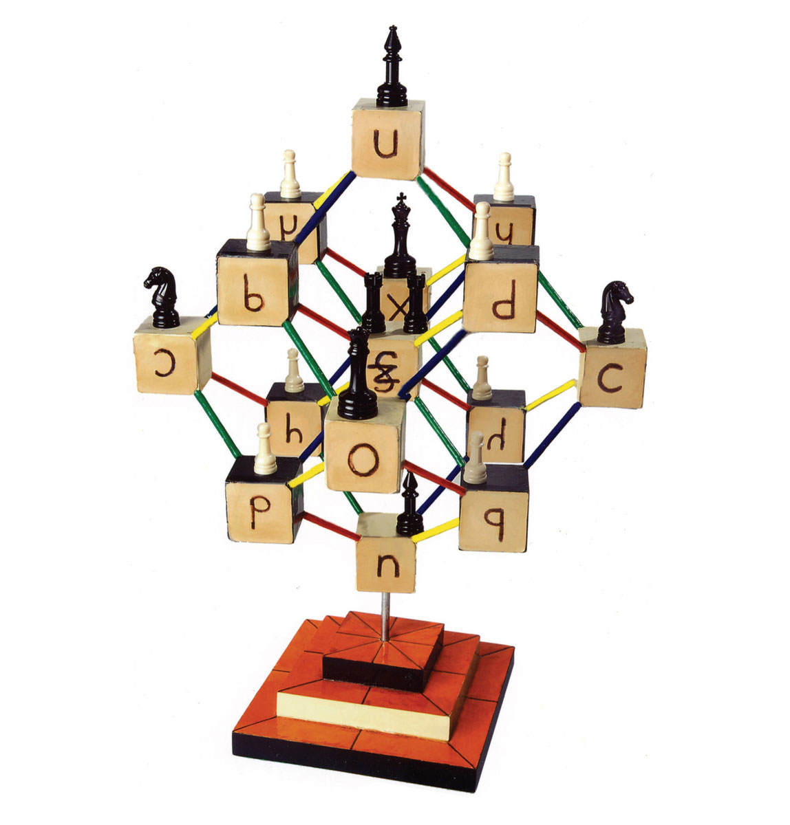 A photograph of Zellweger‘s “Logical Garnet,” a wooden model made of alphabet blocks and chess pieces in which the symmetries of the full three-dimensional figure behind the Logic Alphabet can be seen. 