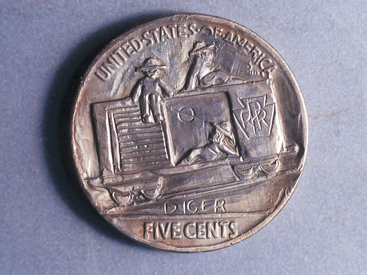 A photograph of a nickel carved into a design depicting three hoboes in a car. The symbol inside the boxcar is a hobo sign meaning “safe route,” and the word “Dicer” under the boxcar means “freight.” This is considered the finest example of reverse carving on a hobo nickel.