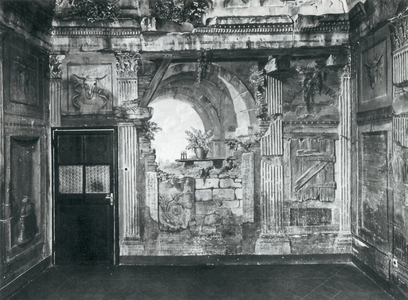 Two photographs of a cell at the Convent of Santa Clara at Santa Trinità dei Monti, Rome. The cell, with a trompe-l’oeil interior that represents a ruined temple, was painted in the seventeen sixties by the French artist Charles-Louis Clérisseau. The first image from circa nineteen eighty shows Clérriseau’s original boarded-up panel replaced with a functional door. 
