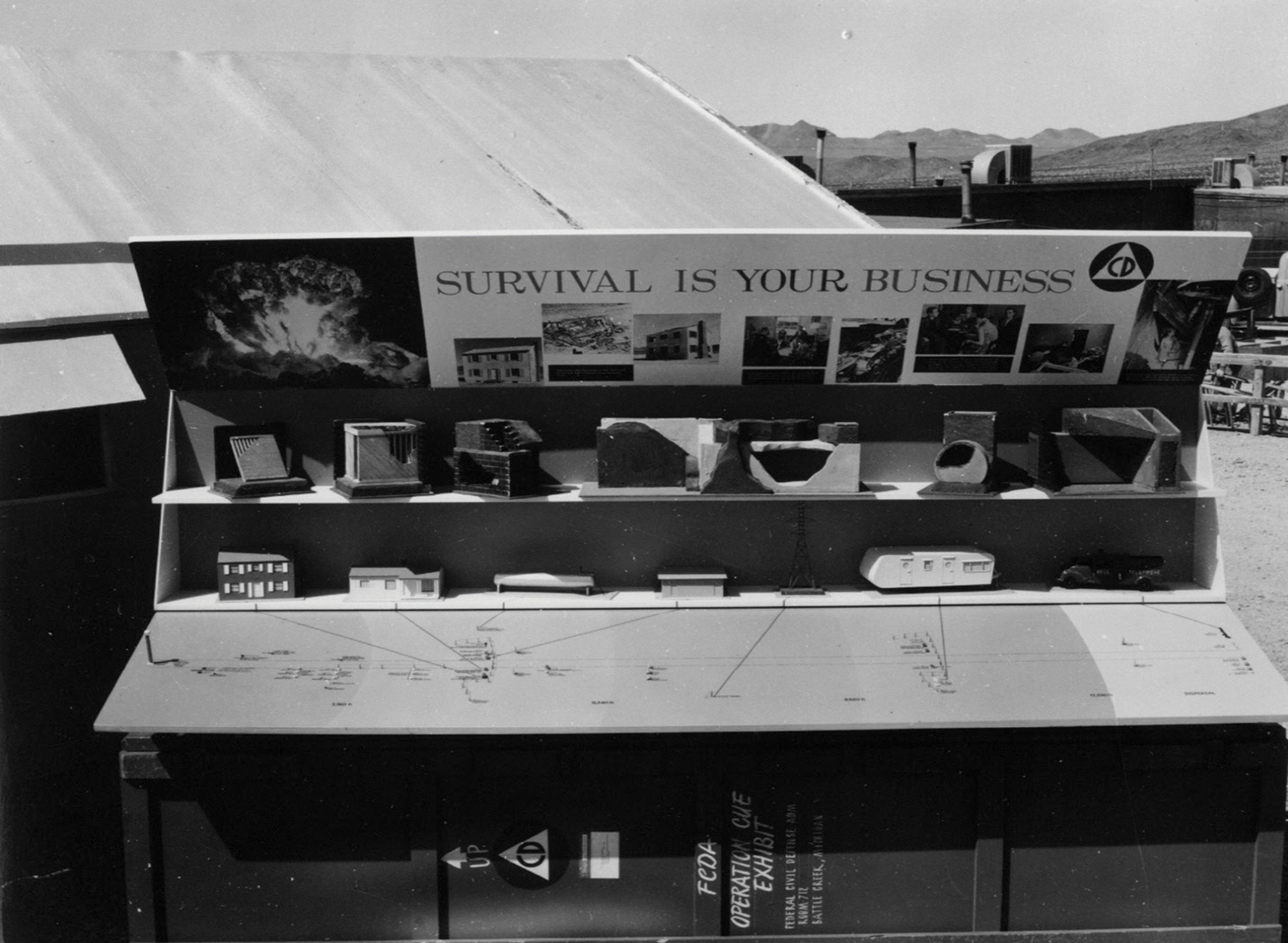 A photograph of a display case at the test site with information about Operation Cue. 