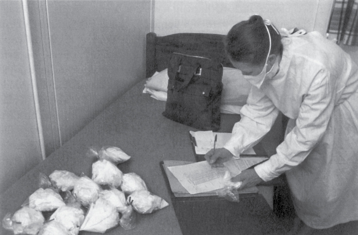 Staff member at the CCU counting out the volunteers’ tissues used in
twenty-four hours at the height of a cold. The bags, each containing five tissues,
were later weighed to calculate the weight of nasal secretions produced.
An experiment at the Common Cold Unit on how viruses are spread. From the collection of Keith R. Thompson.