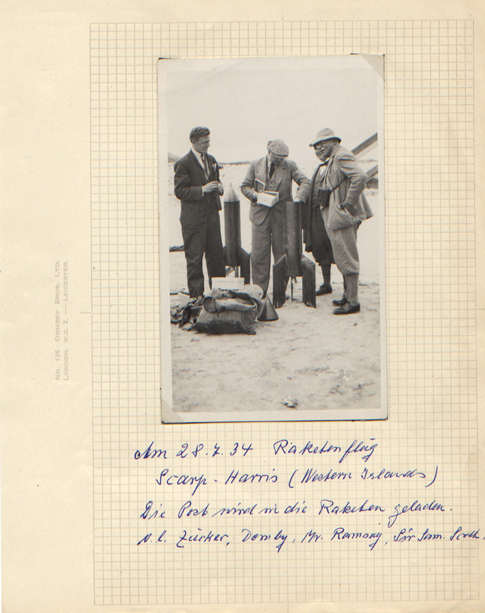 A page from the scrapbook with a photo of Zucker watching as his experimental rocket is packed with letters ready for the Scarp-Harris launch.
