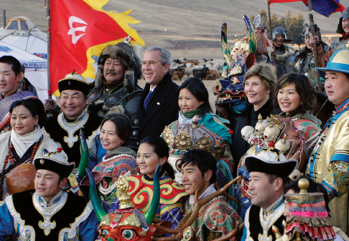 George W. Bush and Laura Bush standing with traditionally dressed men and women in Mongolia.