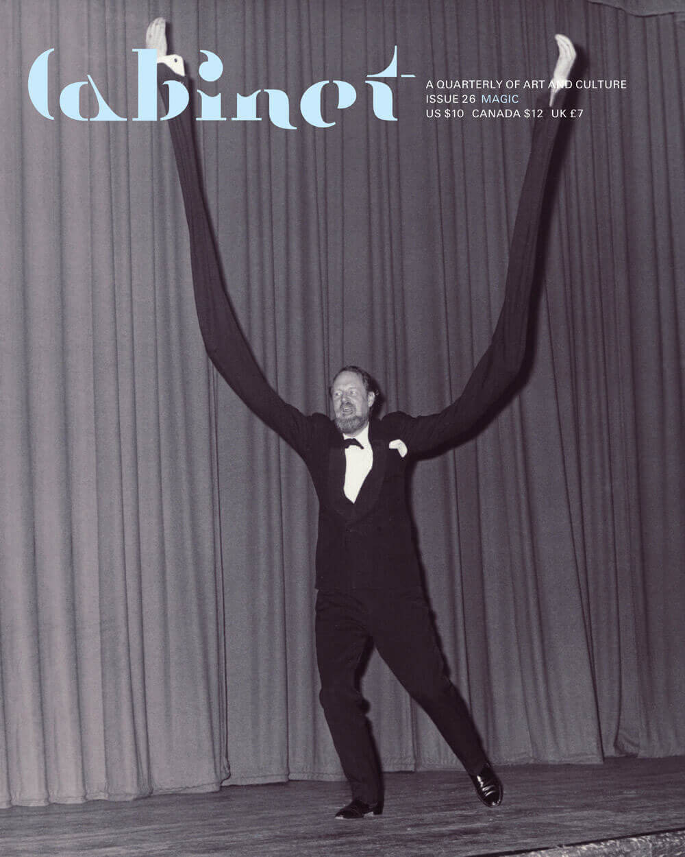 A photograph of British magician “Mad Earl” Norman Caley gesticulating wildly with long, prosthetic arms during a 1965 performance at St. Pancras Assembly Hall in London.