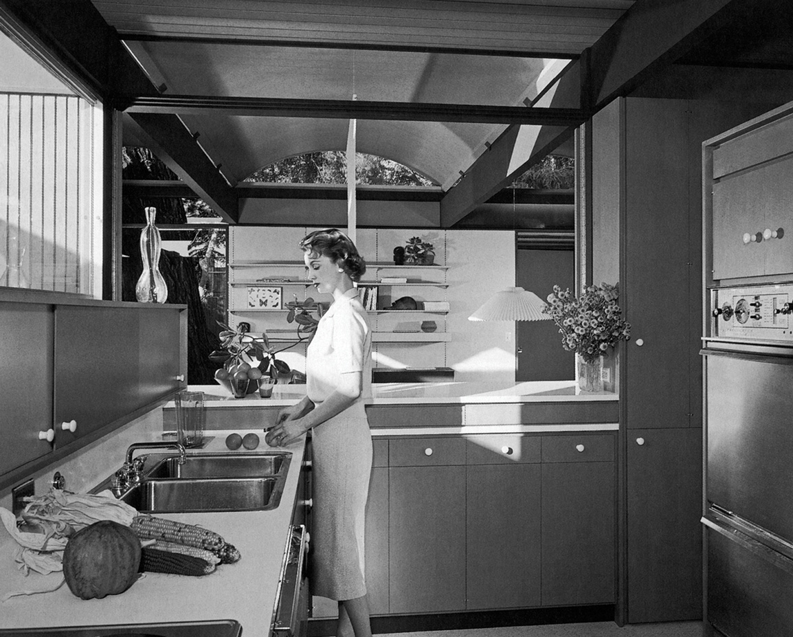 A photograph of Ruth Bass in the kitchen of the Bass House (Case Study House No. 20), Altadena, California, nineteen fifty eight. Conrad Buff, Calvin Straub, Donald Hensman, architects. 