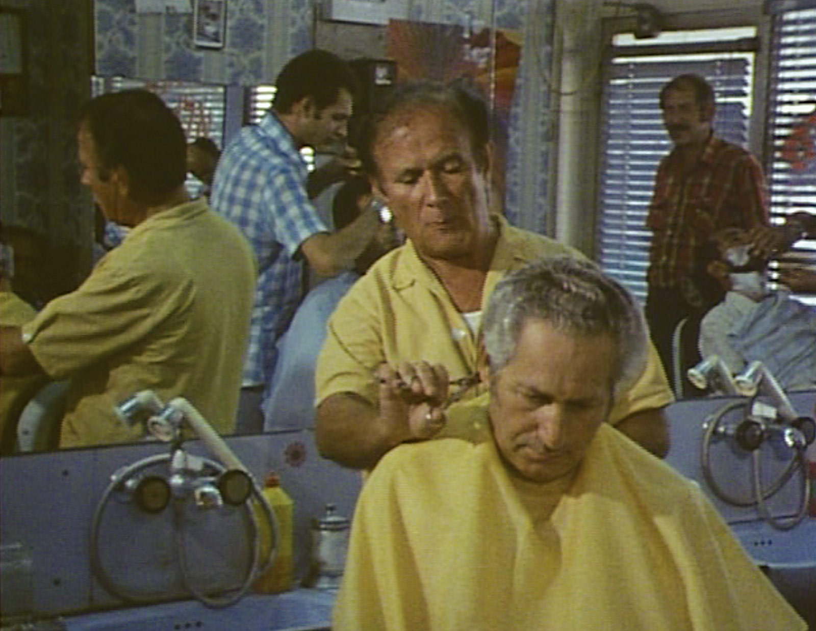 Still from the nineteen eighty five film “Shoah,” by Claude Lanzmann, depicting a scene in a barber shop from various angles.
