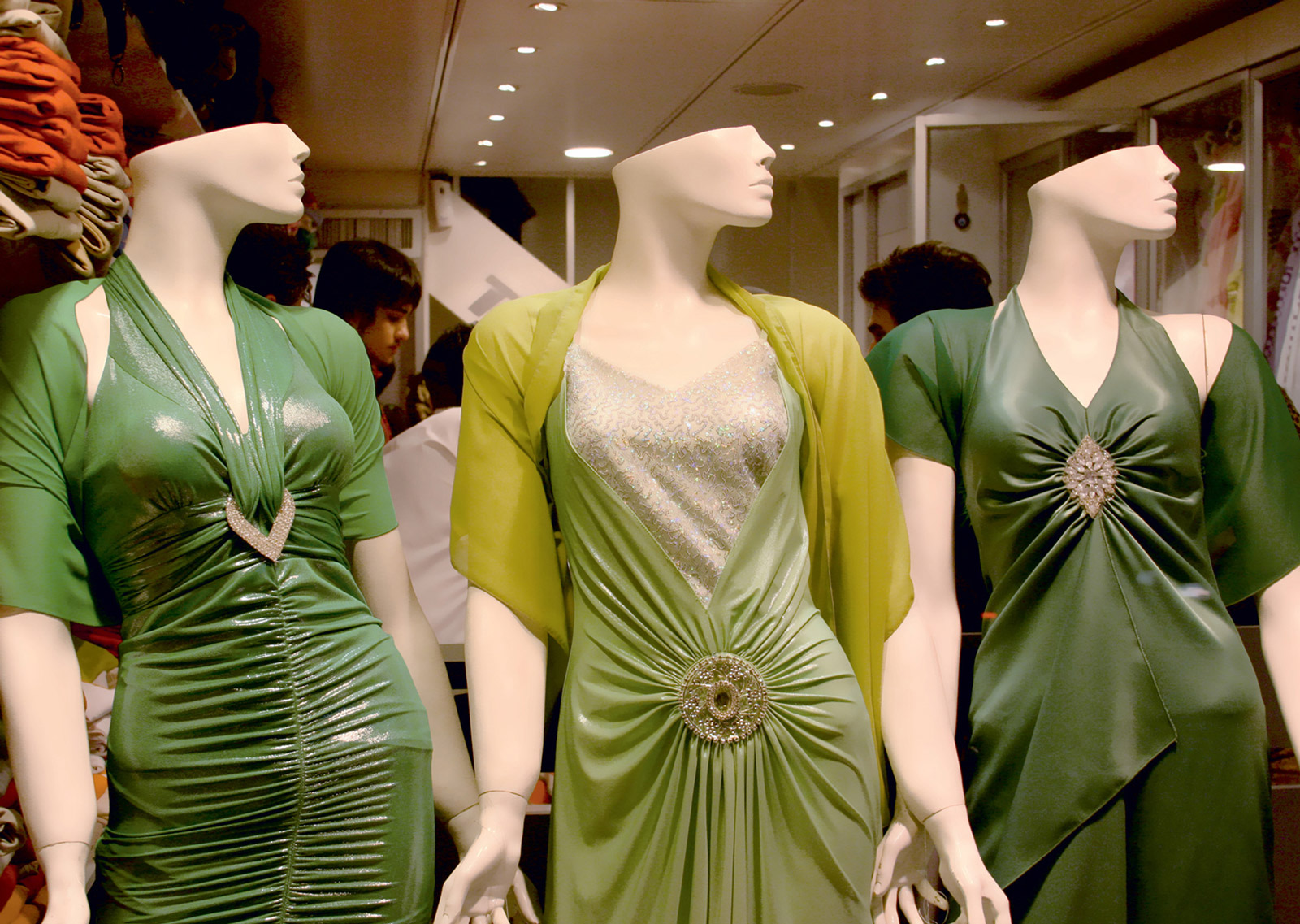 A photograph of three mannequins dressed in green dresses in a department store in Shiraz, Iran.