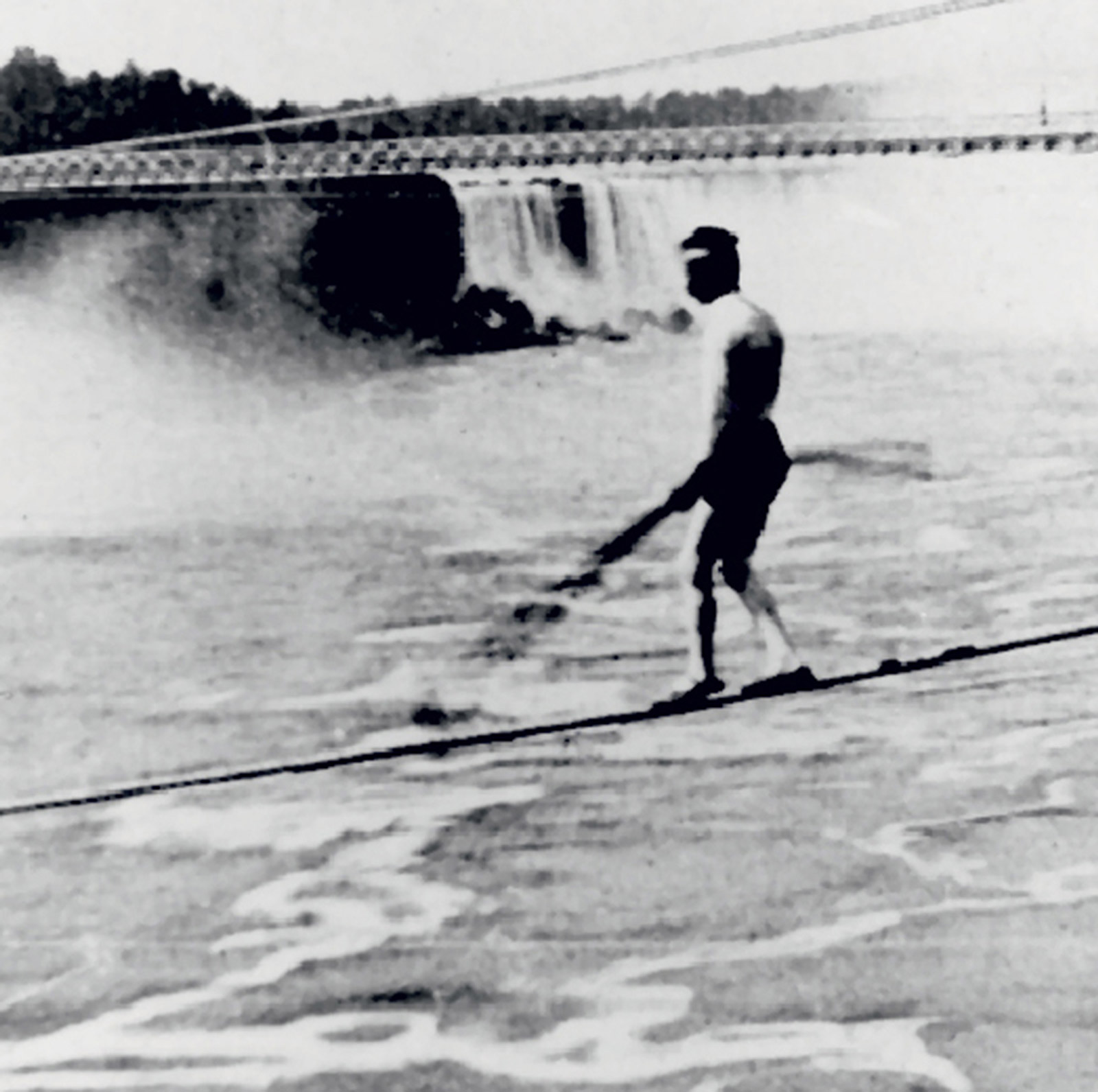 A photograph of Stephen Peer walking a tightrope over Niagara Falls.