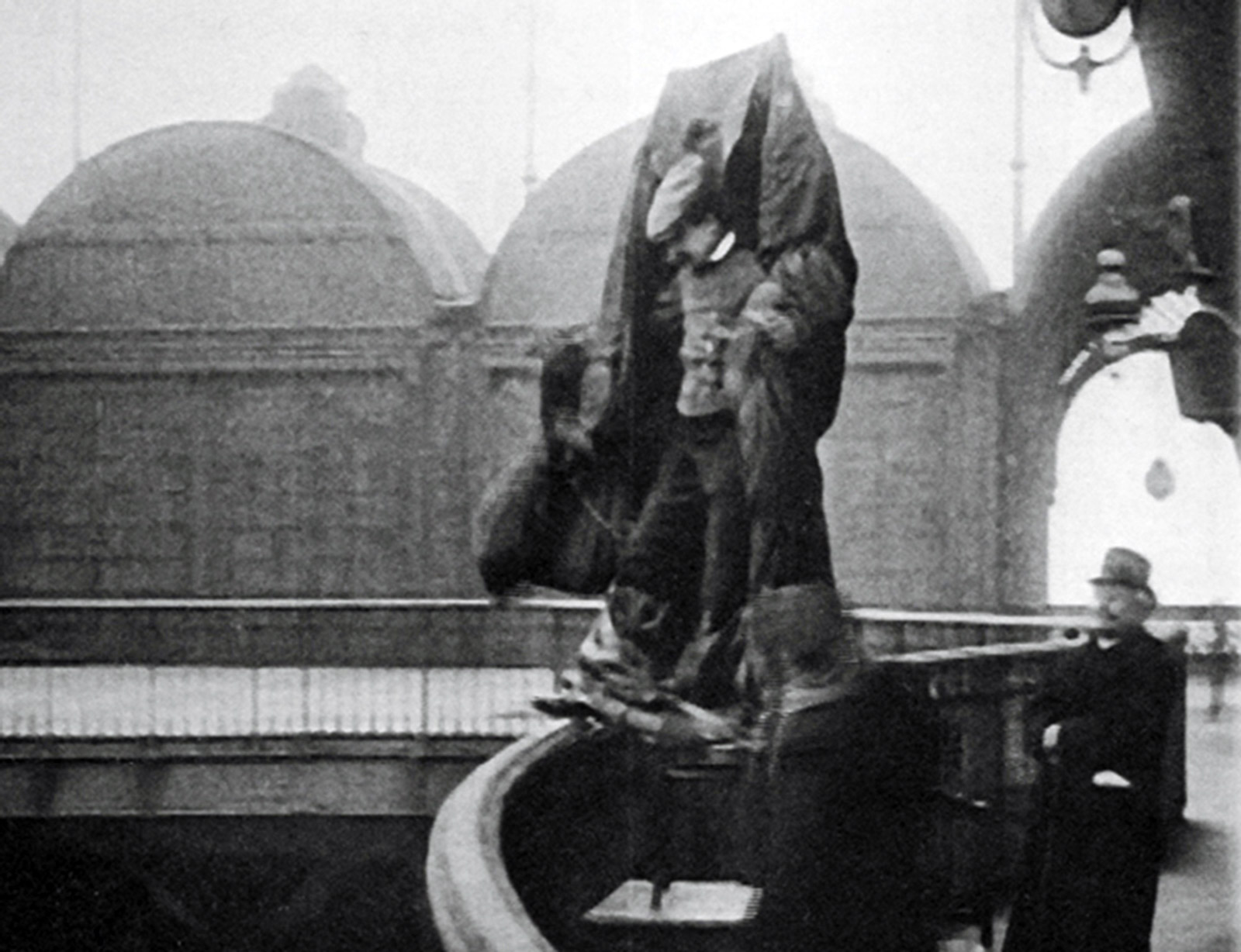 A photograph of Franz Reichelt stepping off the observation deck of the Eiffel Tower.