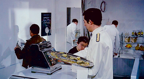 A still from Jacques Tati's 1967 film Playtime which shows plaice being served.