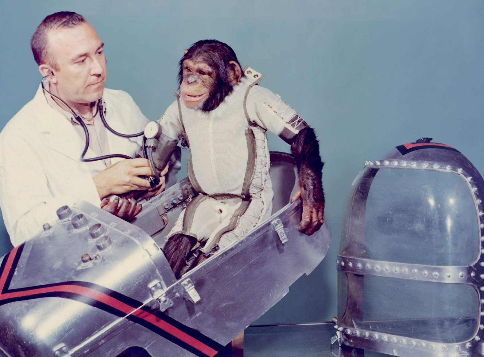 A photograph of the most famous of America’s astrochimps, Ham, seen with this handler and the capsule he would make his January 1961 suborbital flight in. 