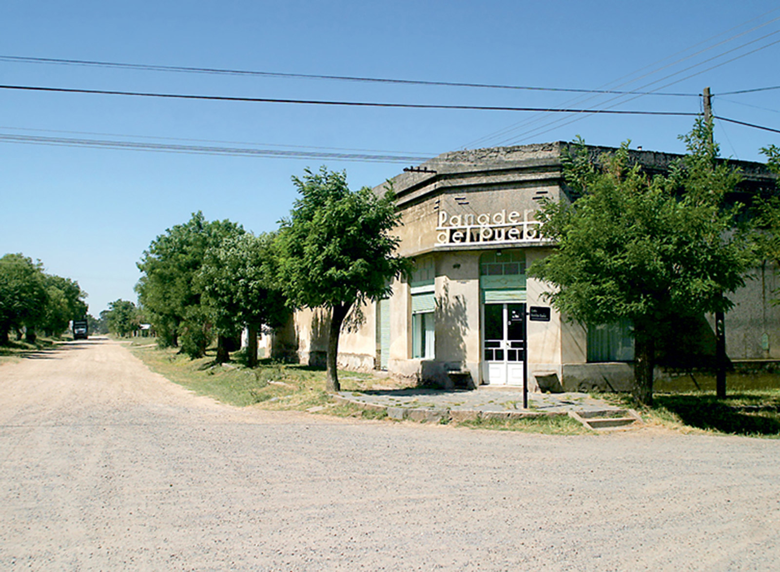 A photograph of a storefront and deserted street in Los Pinos, Argentina. 