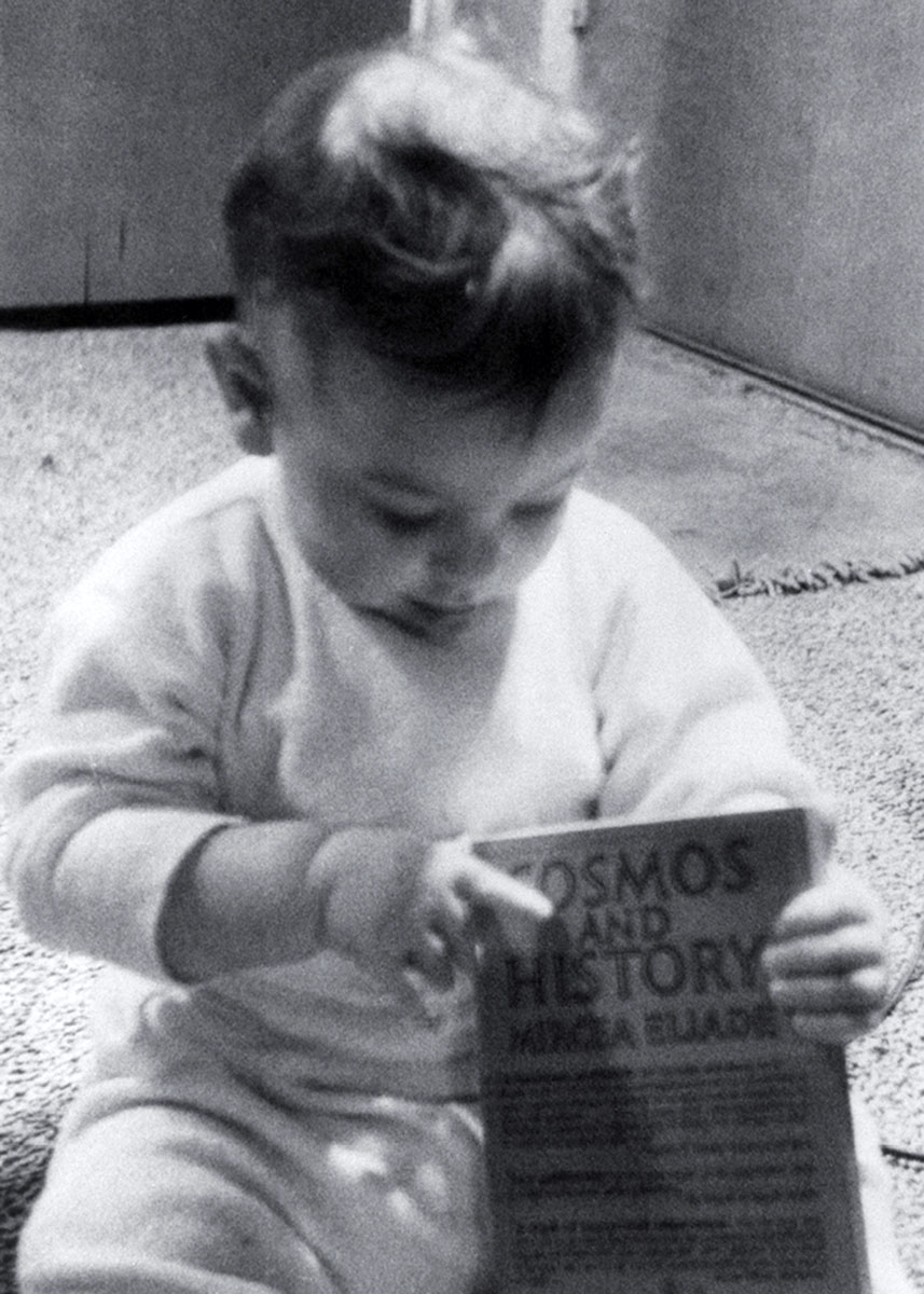 A 1959 photograph of Dorion Sagan holding Mircea Eliade’s book “Cosmos and History.”