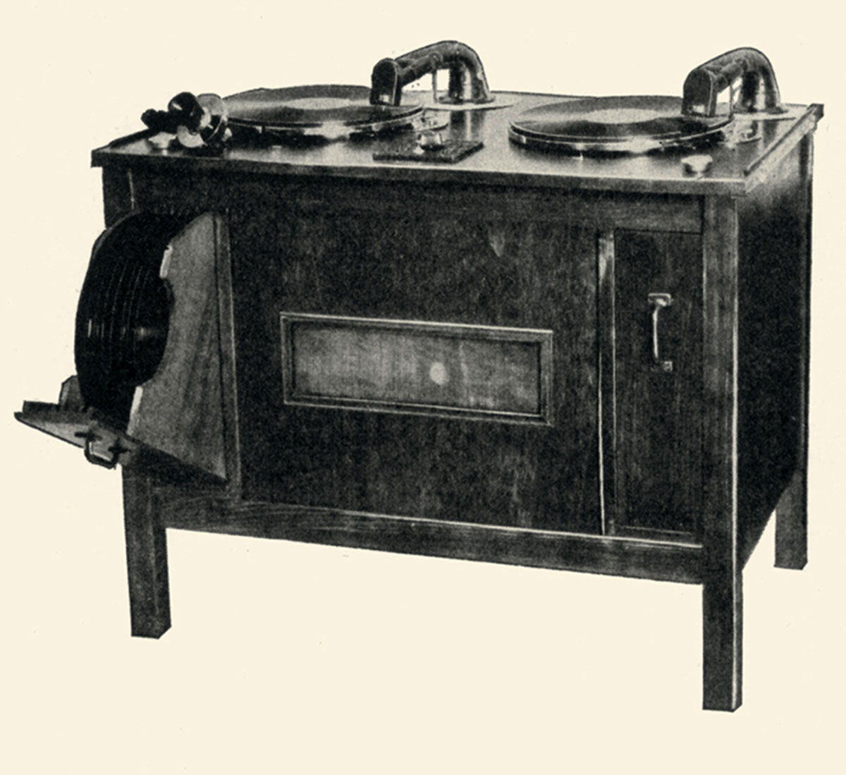 A circa 1929 photograph of a motio-tone non-sync turntable unit in a wooden desk cabinet.