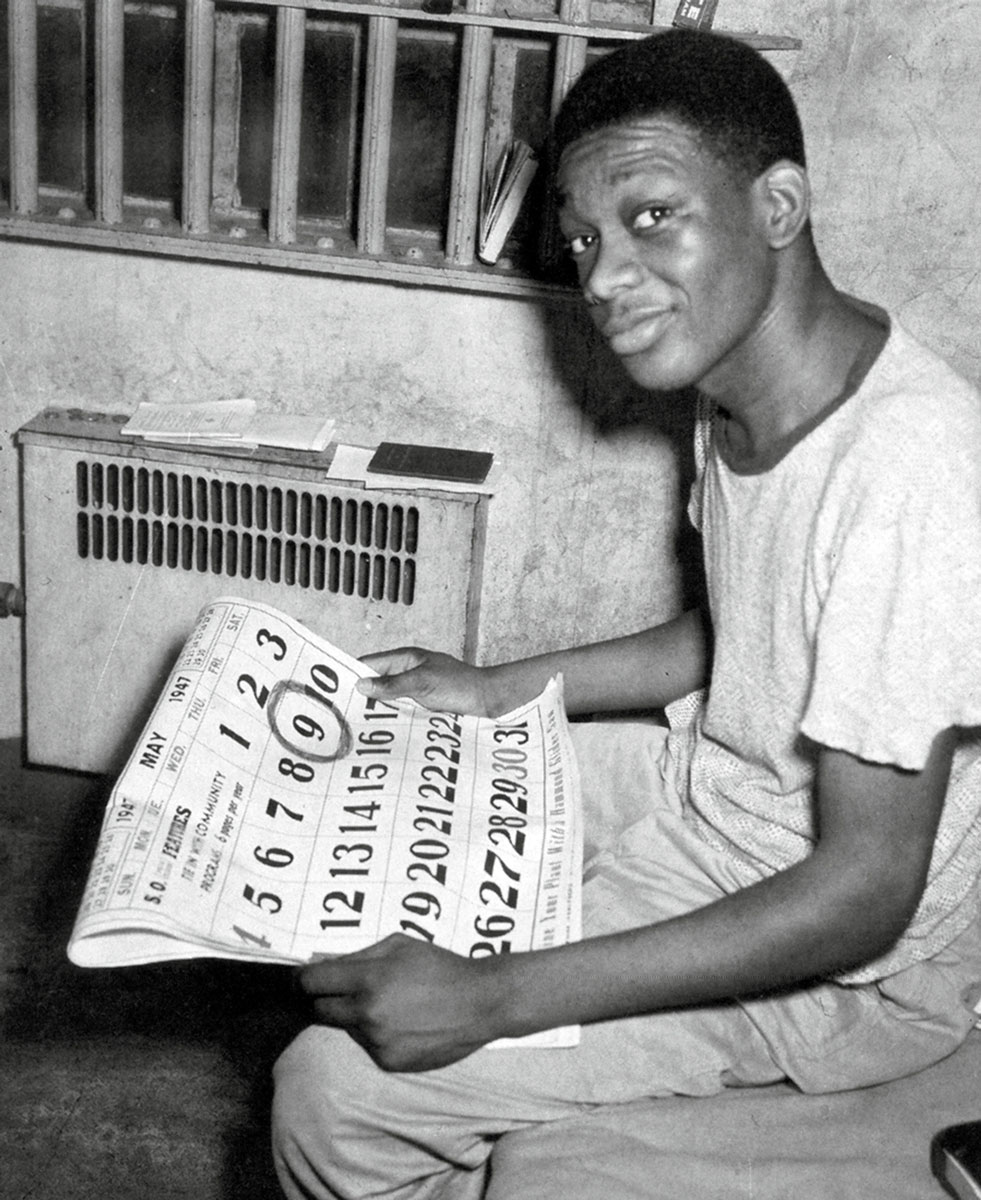 A photograph of Francis, yet to be reshaved, holding a calendar with his upcoming, second execution date of 9 May nineteen forty-seven encircled.