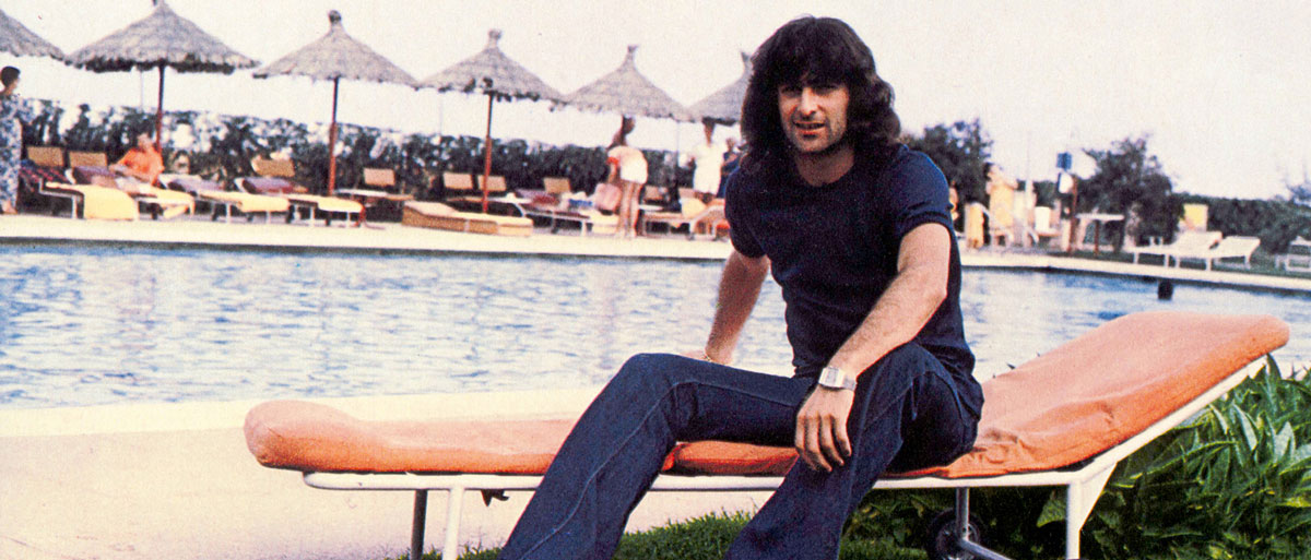 A photograph of Mario Kempes, the Argentinian striker who scored two goals in the nineteen seventy-eight World Cup final against the Netherlands. He is photographed relaxing by a pool.