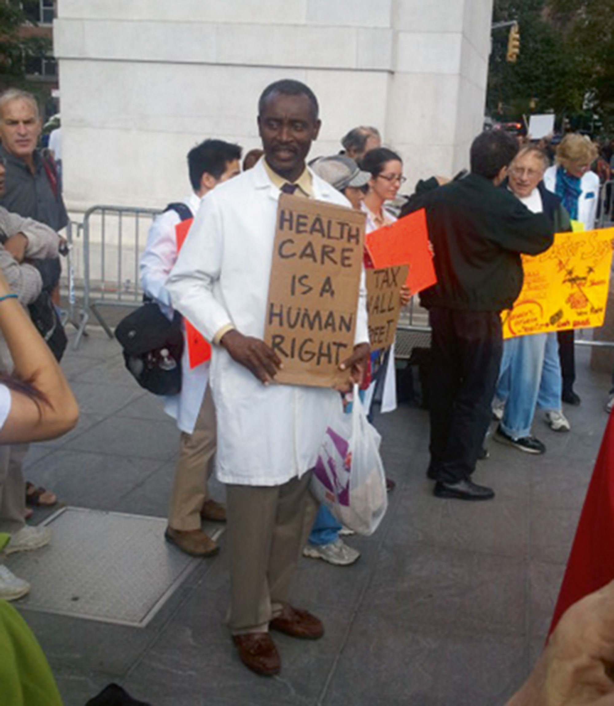 A twenty eleven photograph of a person holding a protest sign that reads “Healthcare is a human right.”