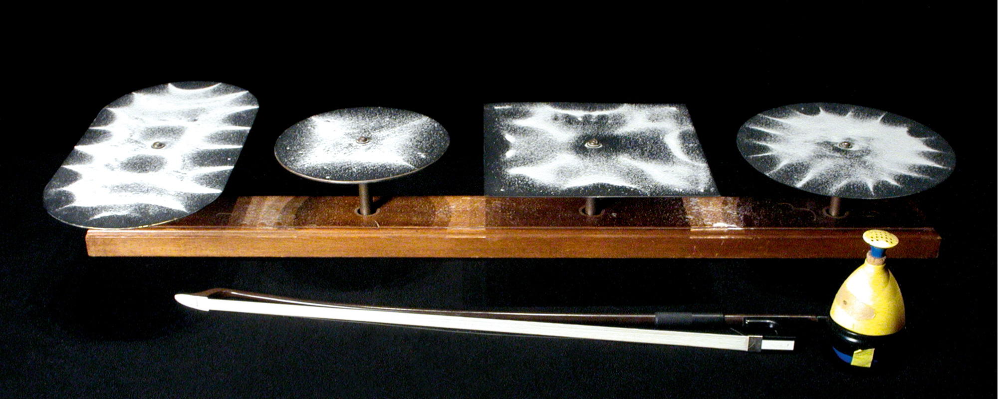 Chladni plates showing different patterns of dispersion caused by their various shapes. Courtesy Harvard Natural Sciences Lecture Demonstrations.