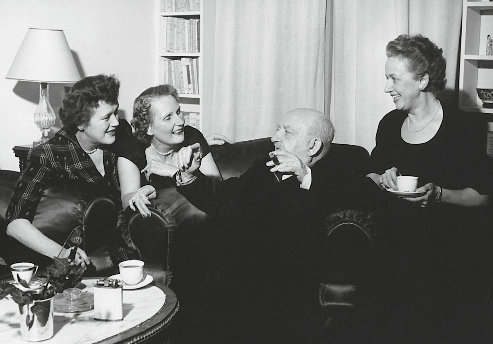 A nineteen fifty-three photograph of Curnonsky holding court. Julia Child’s appears at his right. 