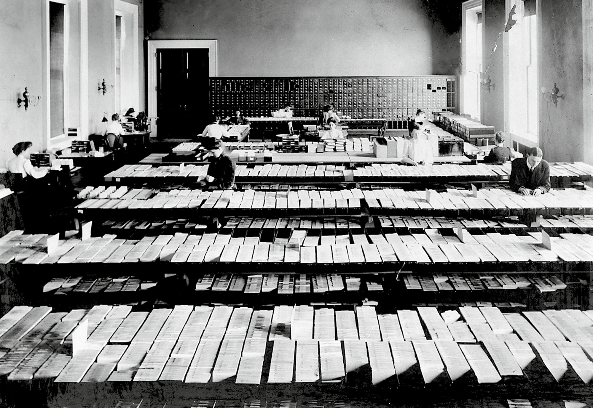 A photograph of people at work on the card catalogue of the Library of Congress in Washington, DC. The photograph was taken between nineteen hundred and nineteen twenty.
