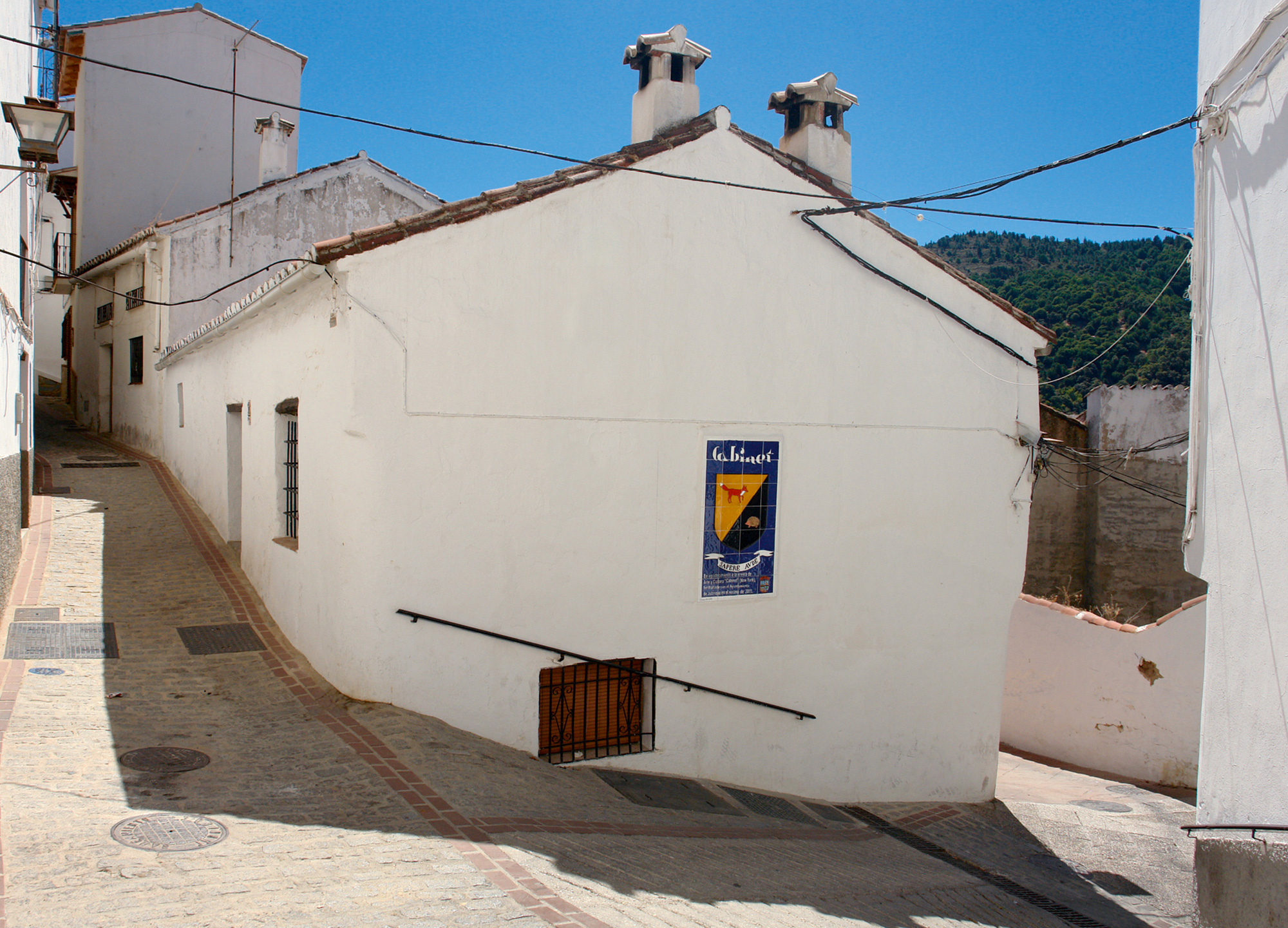 A photograph of Cabinet’s shield finding a permanent home in the Andalusian pueblo blanco of Jubrique.