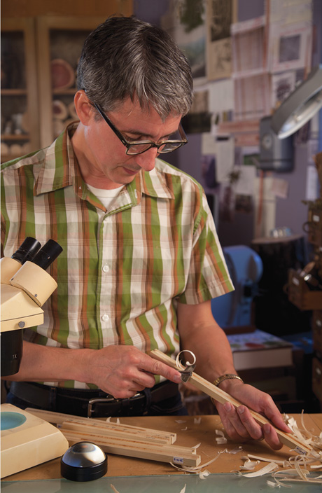 A photograph of the author shaving pencil-thin tree cores with a razor to ready them for analysis.